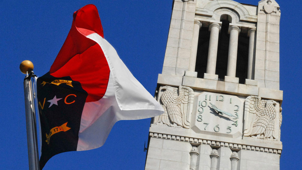 NC State flag flying in front of NCSU belltower