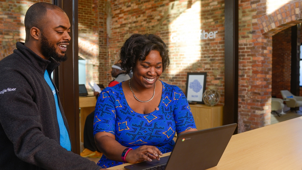 Alumna Tia Bethea chats with a coworker at the Google Fiber Space in downtown Raleigh.