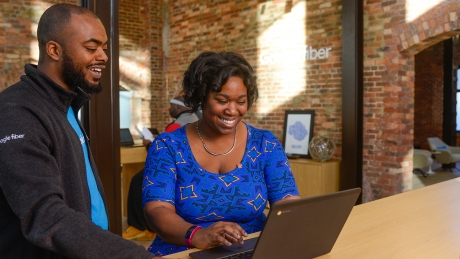 Alumna Tia Bethea chats with a coworker at the Google Fiber Space in downtown Raleigh. 