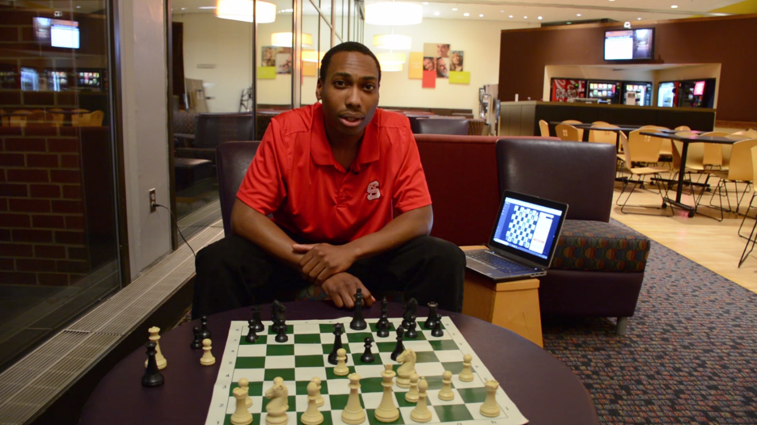 Justin Lockett sits at chess board