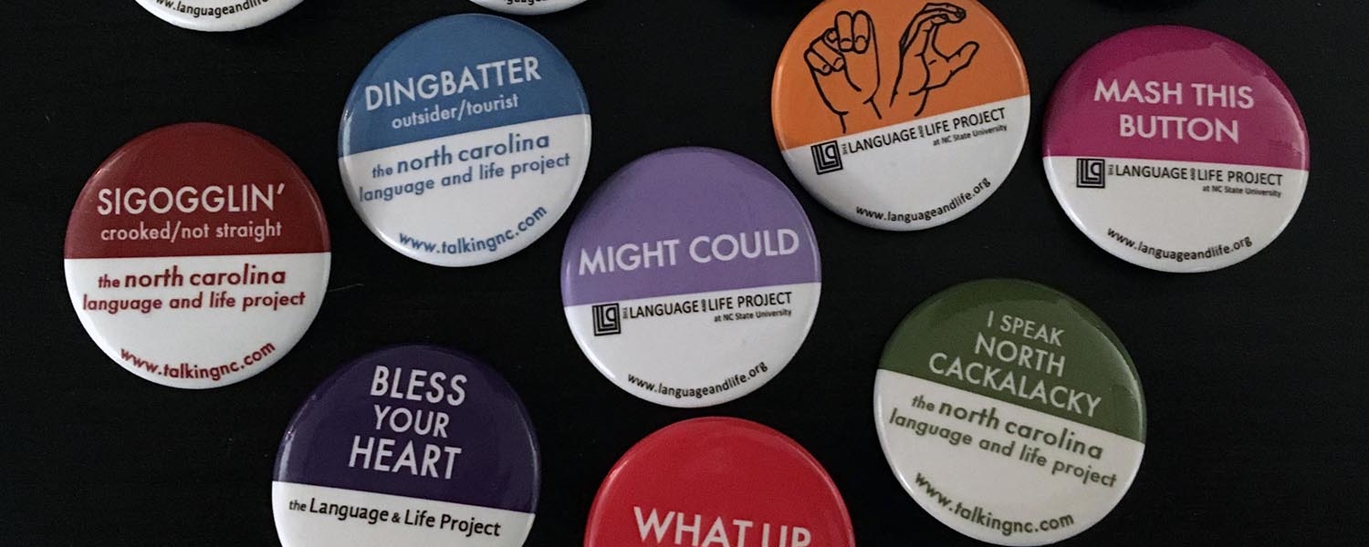 A collection of dialect buttons from the Language and Life Project sit on a black background.