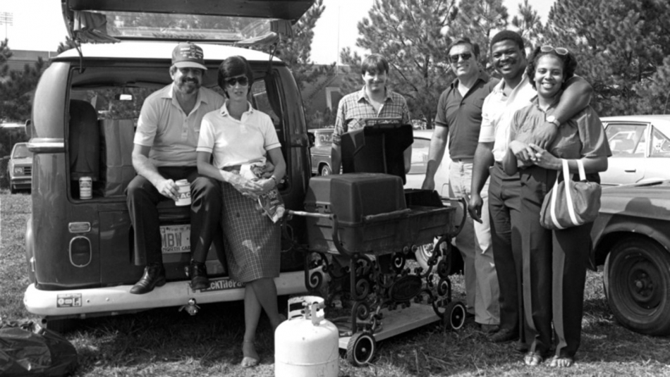 People tailgating with a grill outside Carter Finley Stadium.