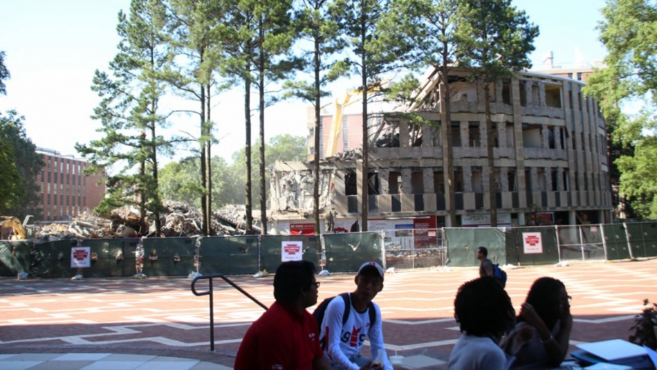 Students watch as Harrelson Hall is demolished