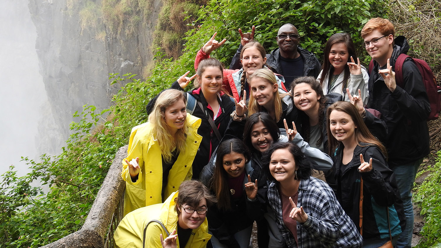 group stands in front of Victoria Falls