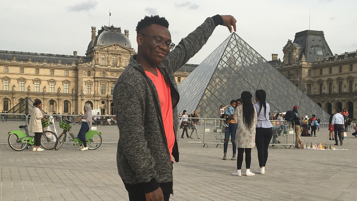 student standing in front of the Louvre