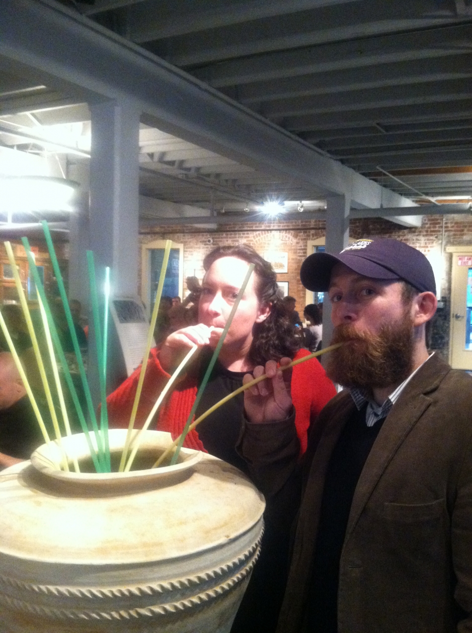 man and woman sip an experimental beer “Sumerian-style” through long straws