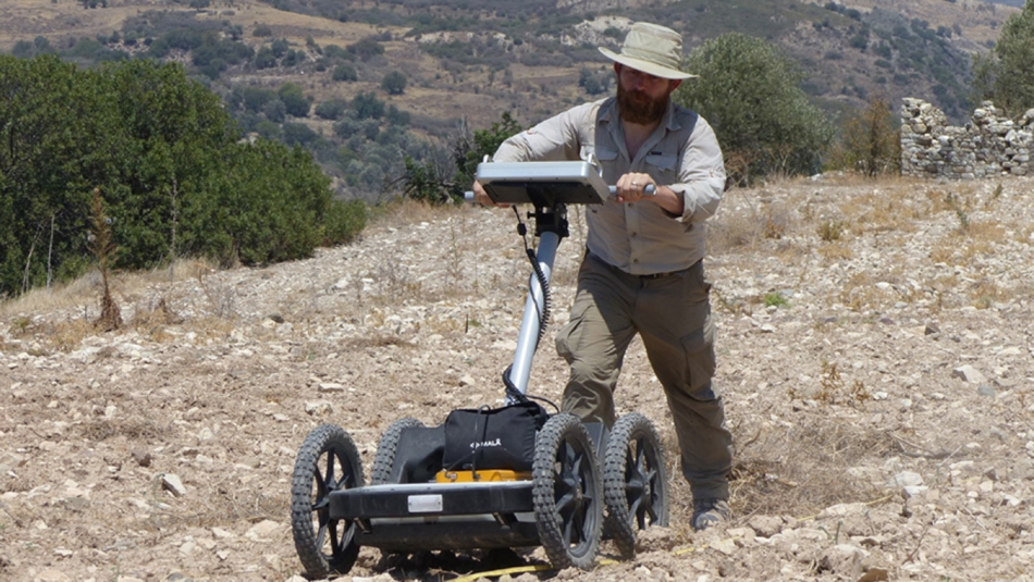 man conducts a ground-penetrating radar survey on the island of Cyprus