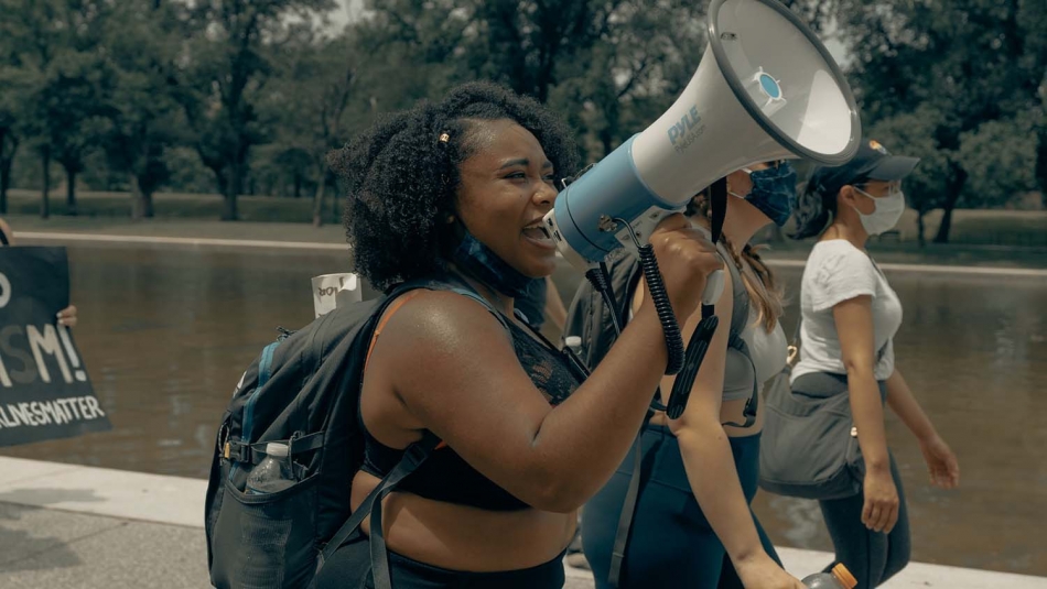 woman marches with megaphone in protest