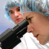 zoom to see a larger version of Lisa Loboa checks on a grad student's research in their lab in Burlington Hall. photo