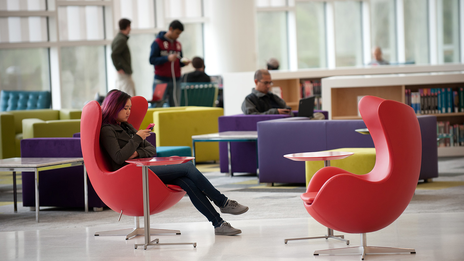 Girl sitting in Hunt Library chair using cell phone