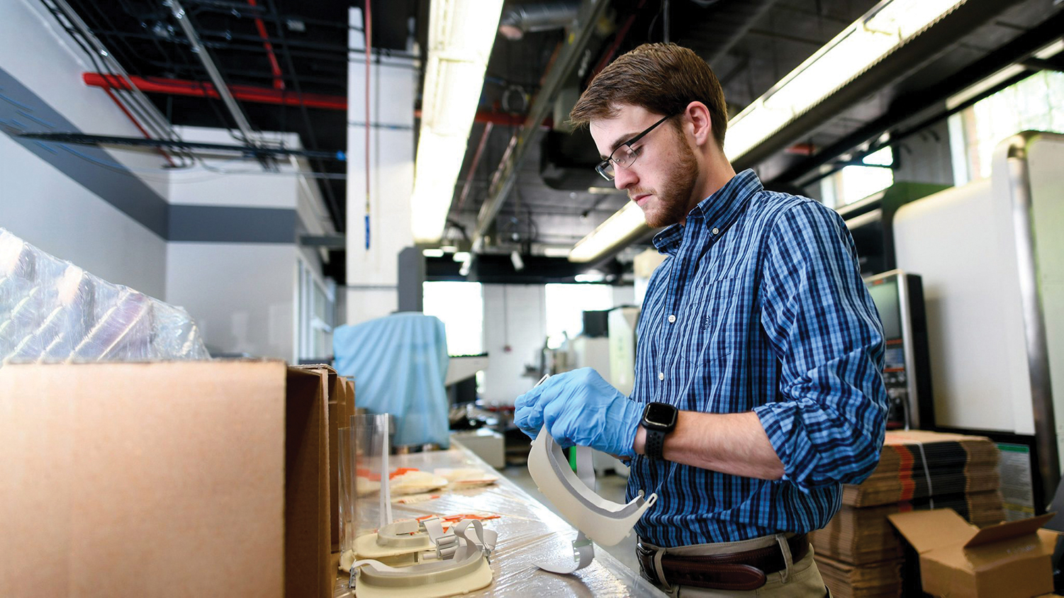 A man works to construct face shields in NC State's 3D-printing lab.