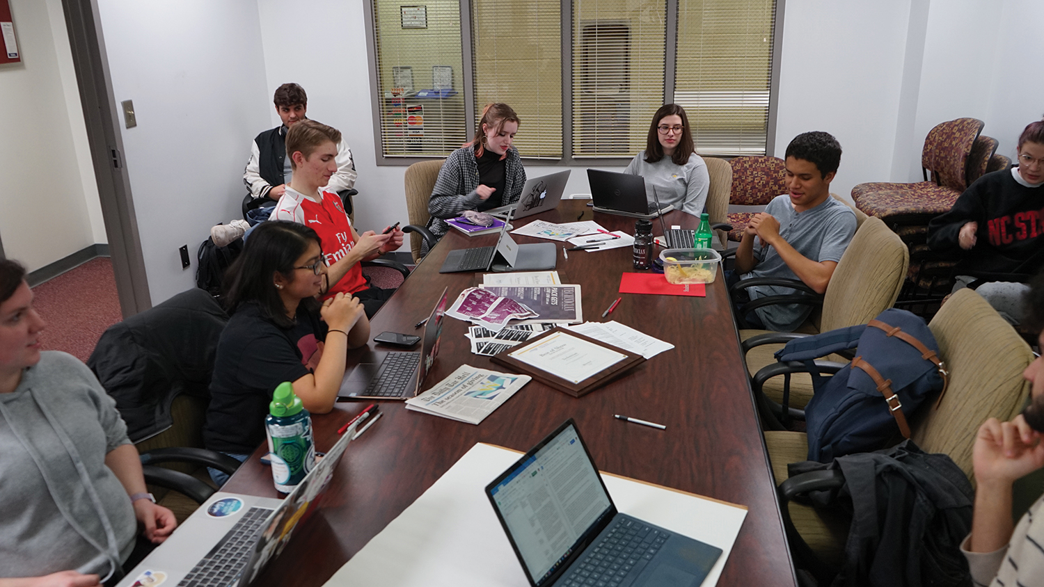 Staff members of the Technician discuss work around a table.